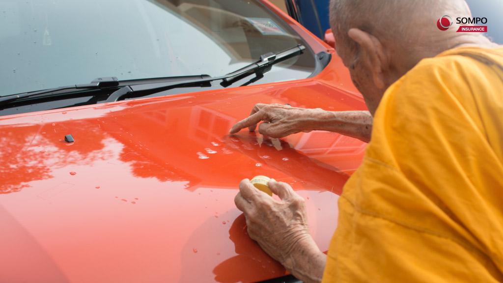พระกำลังท่องคาถาเดินทางปลอดภัยในขณะที่เจิมรถยนต์
